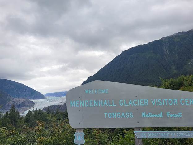 A sign with mountains in the background
AI-generated content may be incorrect.